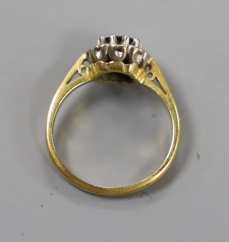 A modern 18ct gold, sapphire and diamond chip set oval cluster ring, size G, gross weight 3.1 grams.